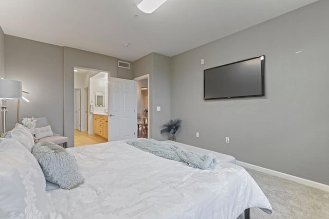 carpeted bedroom featuring ensuite bath