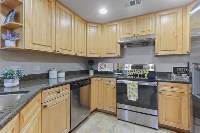 kitchen with appliances with stainless steel finishes, light tile patterned floors, light brown cabinetry, and dark stone counters