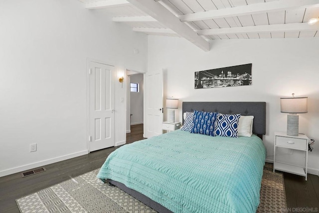 bedroom featuring dark hardwood / wood-style floors and vaulted ceiling with beams