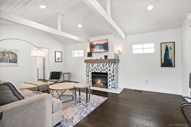 living room with wooden ceiling, dark wood-type flooring, lofted ceiling with beams, and a tiled fireplace