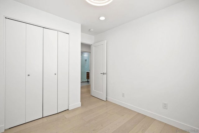 unfurnished bedroom featuring light hardwood / wood-style floors and a closet