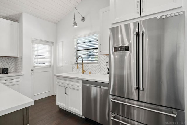 kitchen featuring appliances with stainless steel finishes, decorative light fixtures, white cabinetry, decorative backsplash, and sink