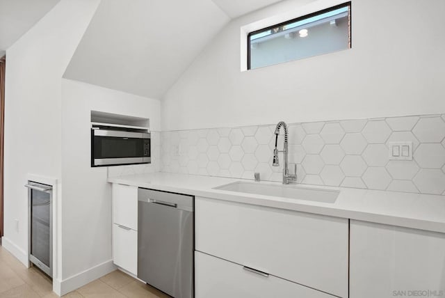 kitchen featuring decorative backsplash, sink, white cabinets, stainless steel appliances, and wine cooler