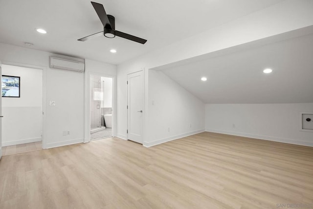 additional living space featuring an AC wall unit, light hardwood / wood-style flooring, and ceiling fan