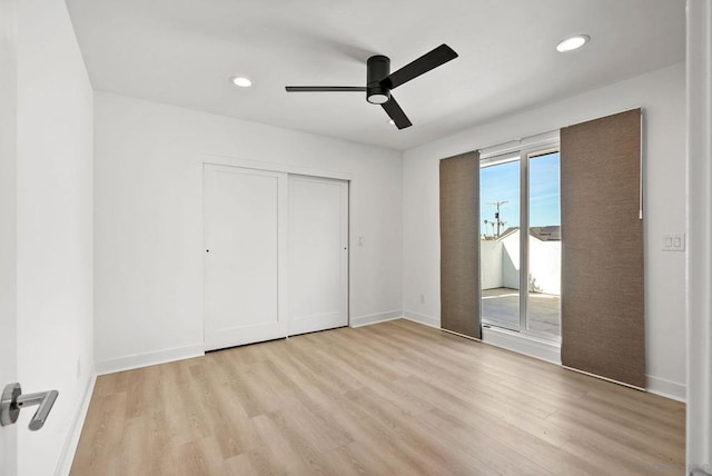 unfurnished bedroom with multiple windows, light wood-type flooring, and ceiling fan