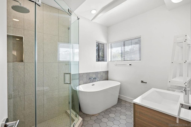 bathroom featuring a healthy amount of sunlight, independent shower and bath, tile patterned flooring, and vanity