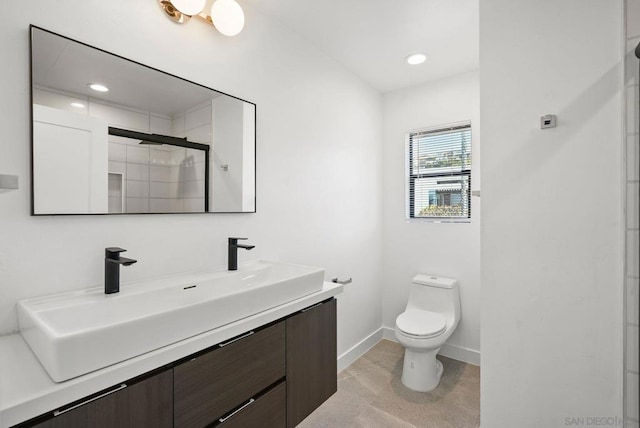 bathroom featuring vanity, toilet, and a shower with door