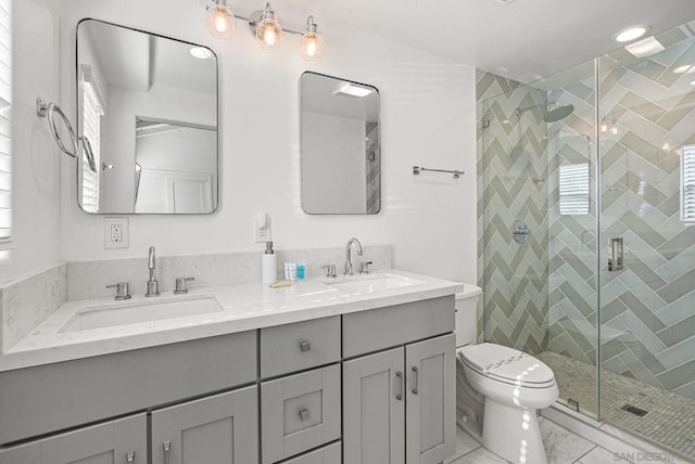 bathroom featuring toilet, a shower with shower door, and vanity