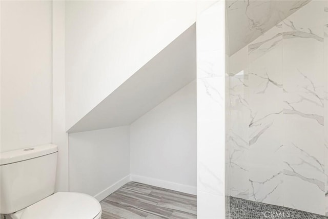 bathroom with toilet and a tile shower