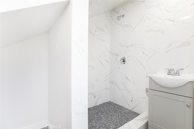 bathroom with tiled shower and vanity