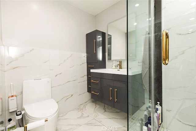 bathroom featuring vanity, toilet, tile walls, and a shower with door