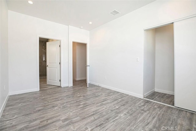 unfurnished bedroom with light wood-type flooring and a closet