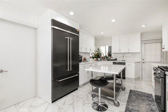 kitchen featuring black appliances, white cabinetry, and decorative backsplash