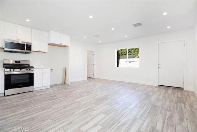 kitchen featuring light hardwood / wood-style floors, white cabinetry, and appliances with stainless steel finishes