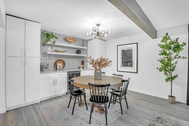 dining space featuring a chandelier, beam ceiling, and light hardwood / wood-style floors