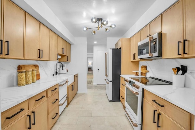 kitchen with sink, white appliances, light stone countertops, and light brown cabinets