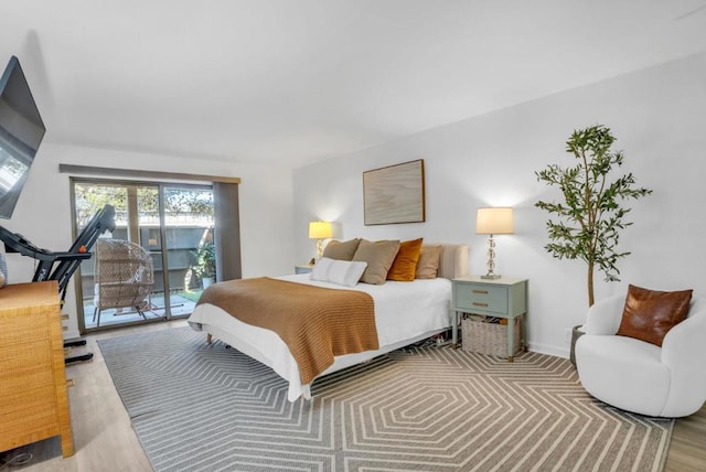 bedroom with access to exterior and light hardwood / wood-style flooring