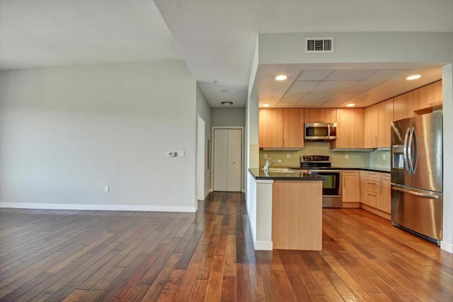 kitchen with stainless steel appliances, sink, light brown cabinets, and dark hardwood / wood-style floors