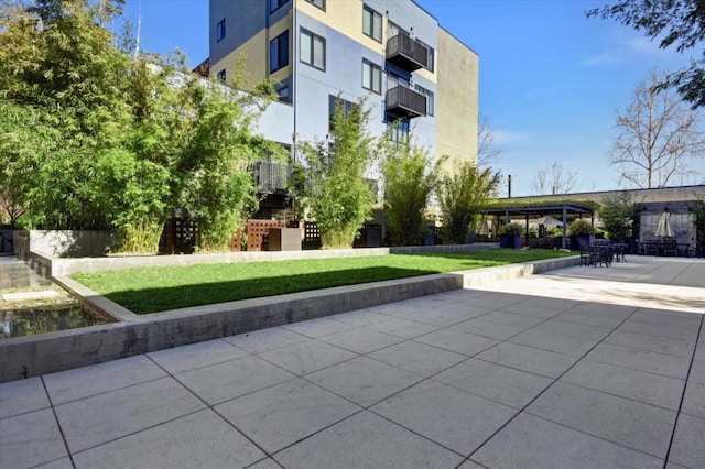 view of home's community with a yard and a patio area