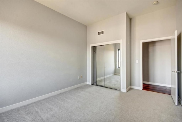 unfurnished bedroom with a closet and light carpet