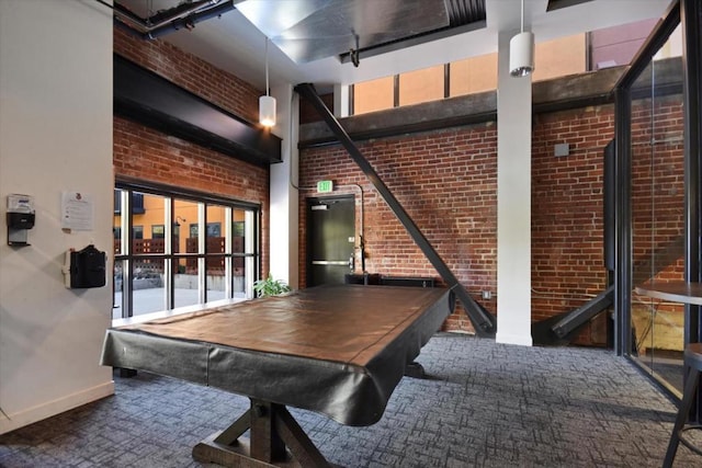 playroom with brick wall, a towering ceiling, pool table, and carpet