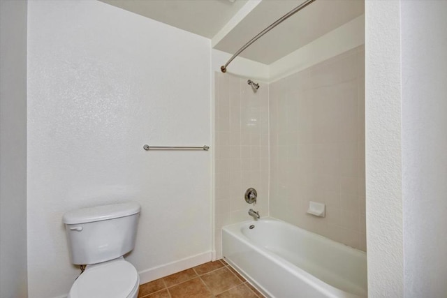 bathroom with tile patterned flooring, tiled shower / bath combo, and toilet