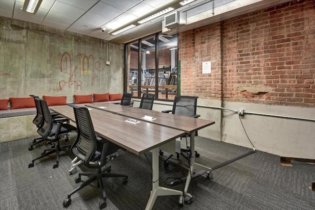 office area with brick wall and carpet flooring