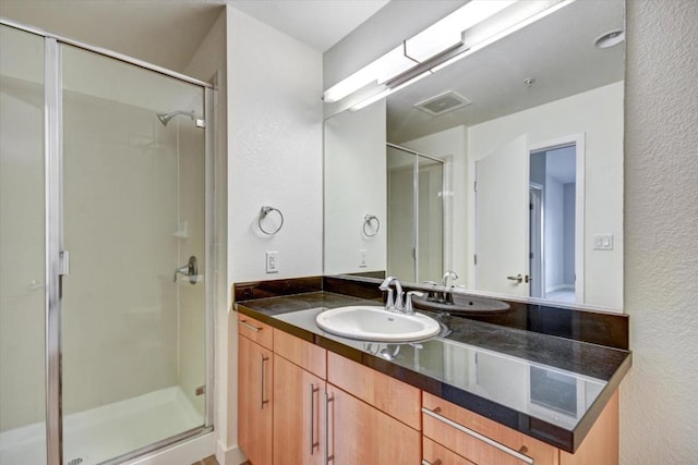 bathroom with vanity and a shower with door