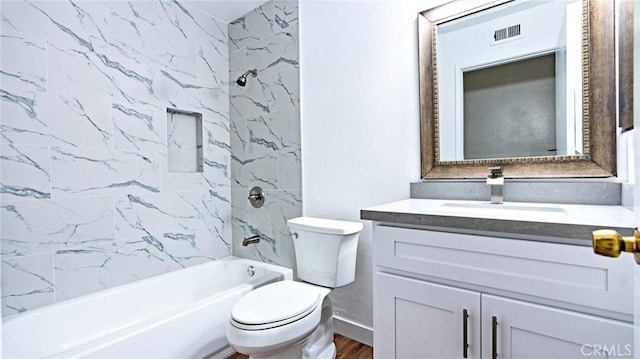 full bathroom featuring hardwood / wood-style flooring, toilet, vanity, and tiled shower / bath