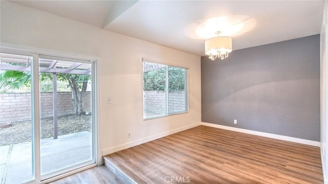 interior space with hardwood / wood-style flooring, a wealth of natural light, and a notable chandelier