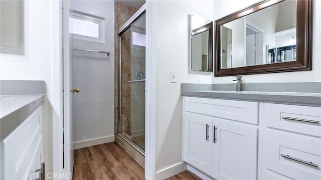 bathroom featuring a shower with door, wood-type flooring, and vanity