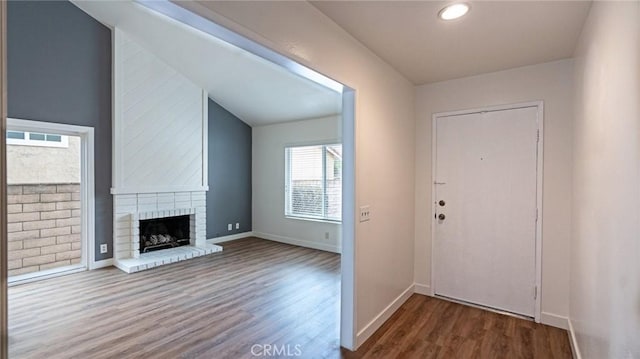 foyer entrance with hardwood / wood-style flooring and a brick fireplace