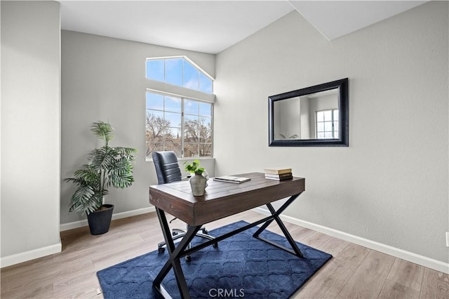 office space featuring vaulted ceiling and light hardwood / wood-style floors