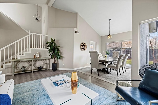 living room with hardwood / wood-style flooring, high vaulted ceiling, and beam ceiling