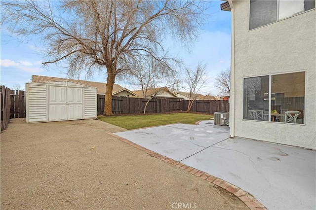 view of yard featuring a shed, a patio area, and central air condition unit