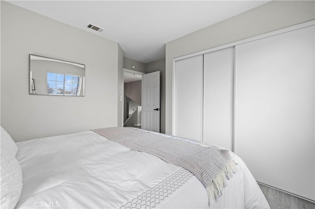 bedroom with wood-type flooring and a closet