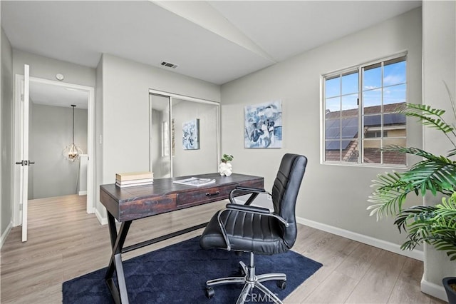 home office featuring lofted ceiling and light hardwood / wood-style flooring