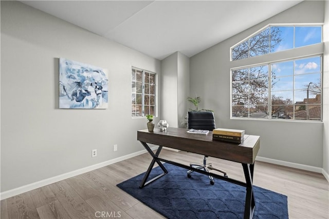 office area featuring vaulted ceiling and light hardwood / wood-style flooring