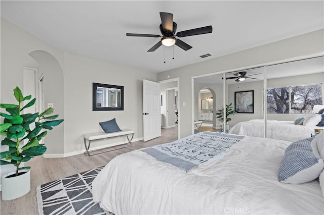 bedroom featuring hardwood / wood-style flooring, ceiling fan, and a closet