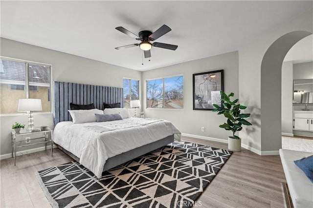 bedroom featuring hardwood / wood-style flooring, connected bathroom, and ceiling fan