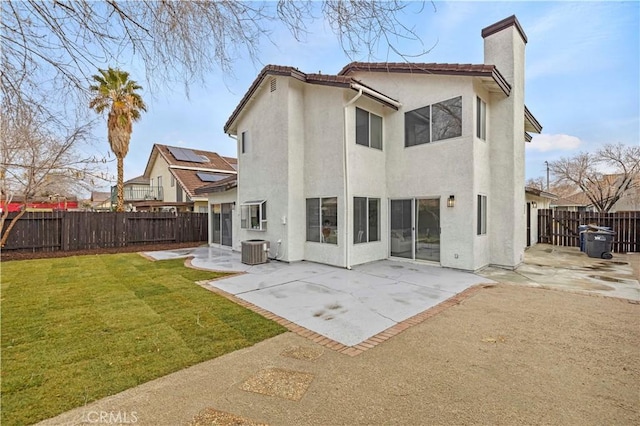 rear view of property with a yard, a patio, and central air condition unit