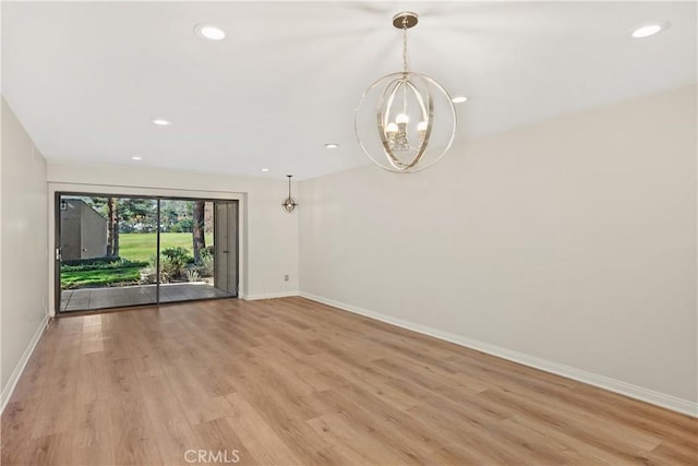 unfurnished living room featuring light hardwood / wood-style floors and an inviting chandelier