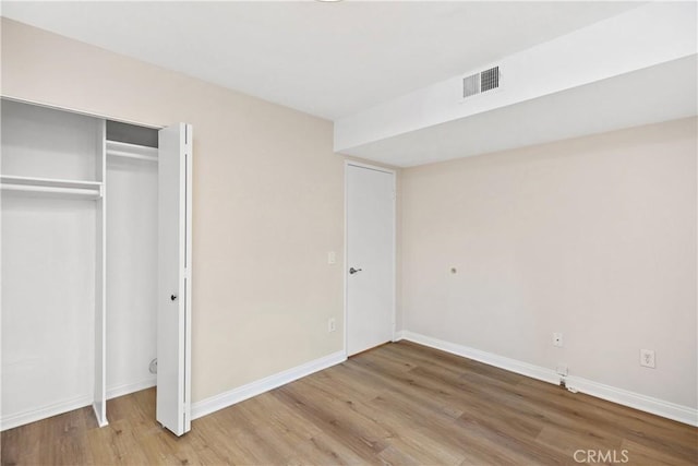 unfurnished bedroom with hardwood / wood-style flooring and a closet