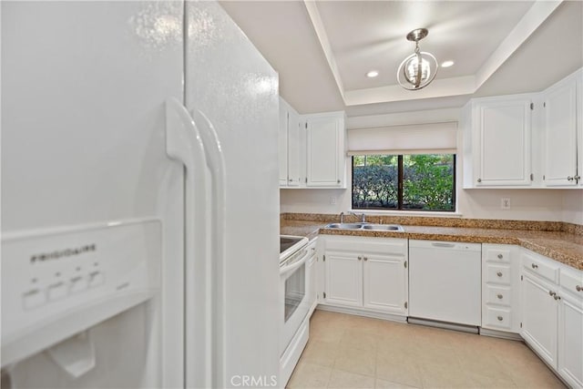 kitchen featuring white cabinetry, white appliances, and a raised ceiling