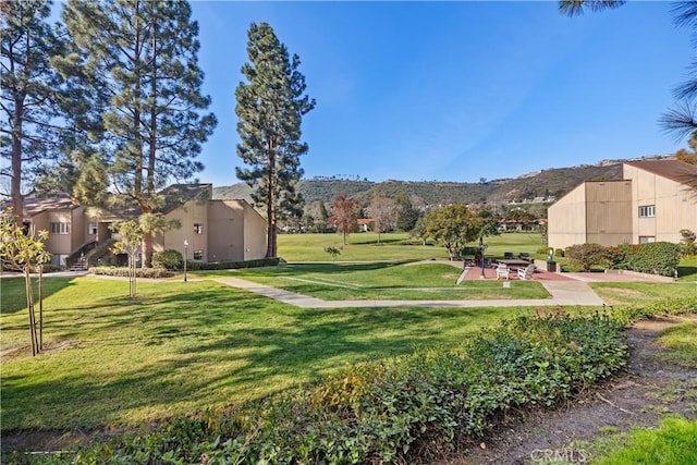 view of property's community featuring a mountain view and a yard