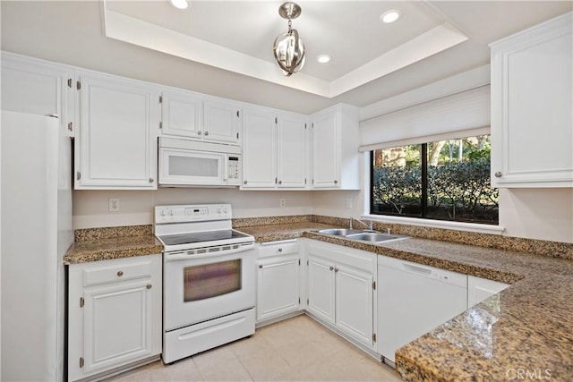 kitchen with white appliances, white cabinets, sink, stone countertops, and a tray ceiling