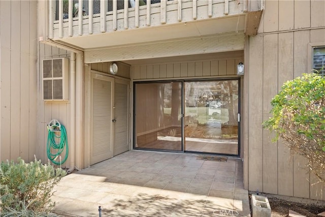 view of exterior entry with a balcony and a patio