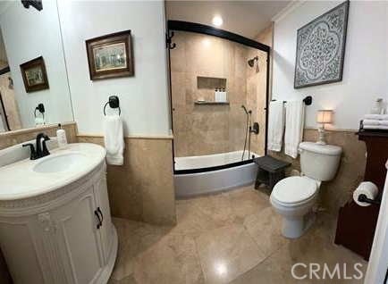 bathroom with crown molding, toilet, walk in shower, and vanity