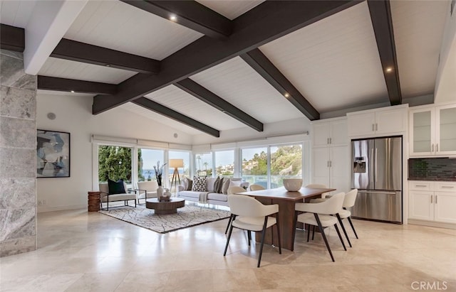 dining space with vaulted ceiling with beams