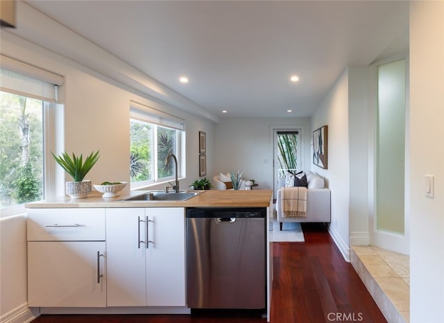 kitchen featuring dishwasher, sink, white cabinets, and dark hardwood / wood-style flooring